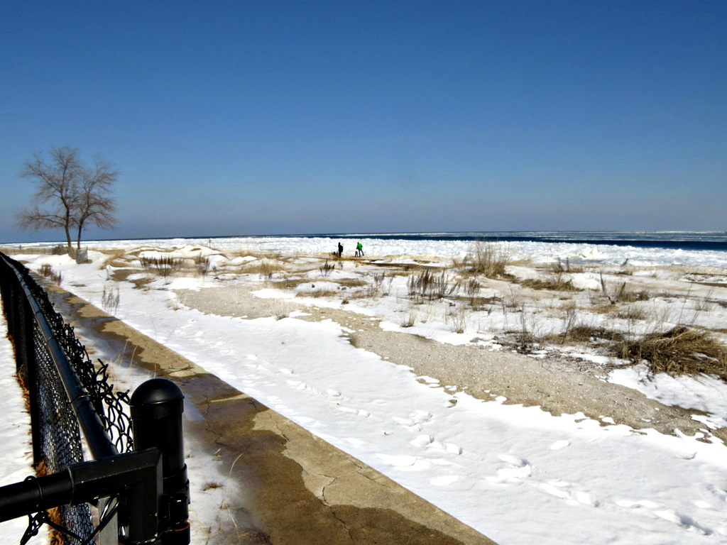 A family walking on the ice at the Lake Huron shore.