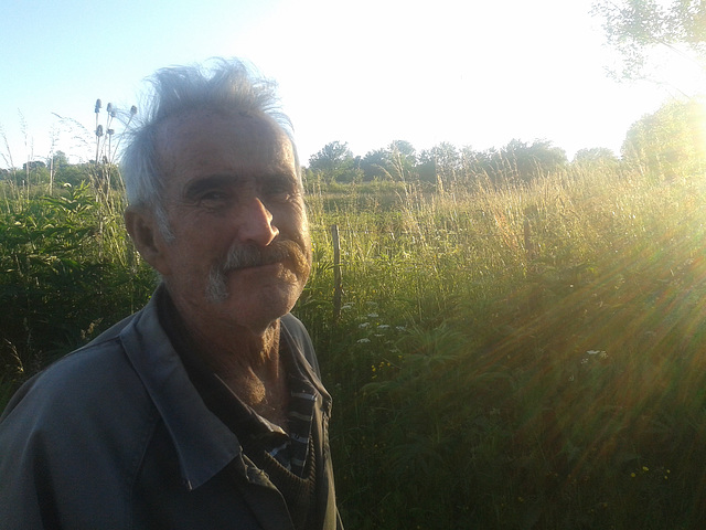 Potrait old man illuminated by the rays of the setting sun
