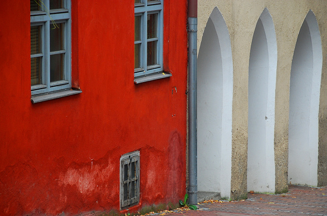 Rotes Haus neben gotischen Bögen