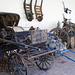 Horse-drawn landau and load wagon.
