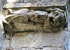 empingham church, rutland   (5) c15  dragon biting man, detail under buttress set off