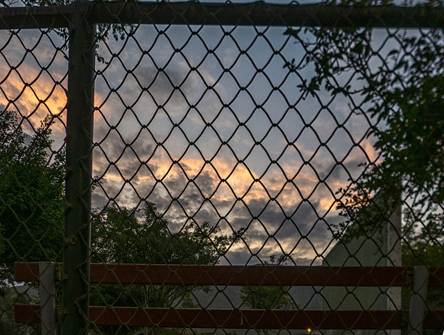 Fence and lonely bench at dusk
