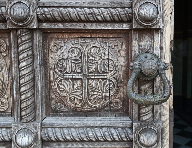 Detail of carved door and bronze knocker