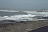 The tide rushing towards the rocks and beach