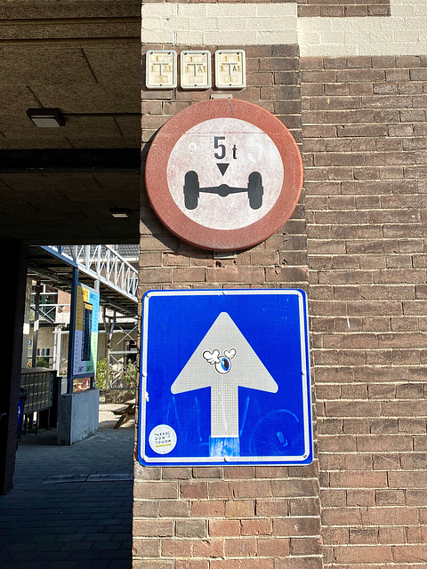 Old sign for axle load and new one-way sign