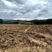 Plowed fields and cloudy sky.