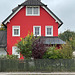 Rotes Haus hinter Lattenzaun