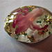 An oval with a hyacinth flower bud and gold leaf