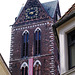 Turm der Wismarer Marien-Kirche lugt zwischen die Häuser am Mark