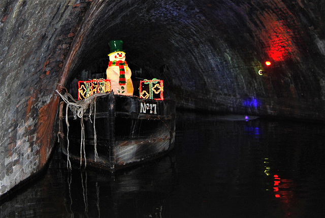 Snowman on a bench in a boat in a tunnel.