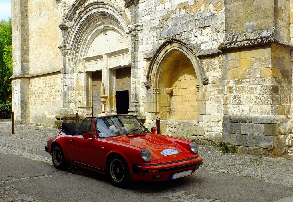 Vieille Porsche devant le porche de la vieille église de Monpazier