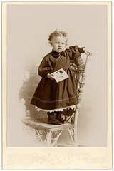 Girl Holding Photo and Standing on Chair