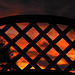Sunset viewed through a fence.