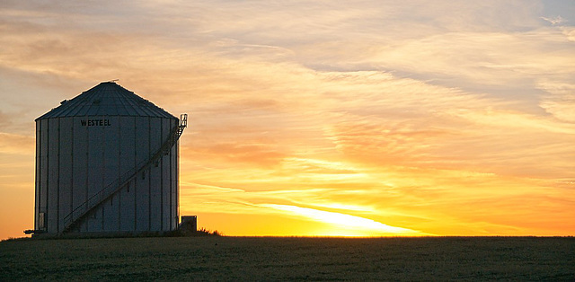 a grain bin at sunset