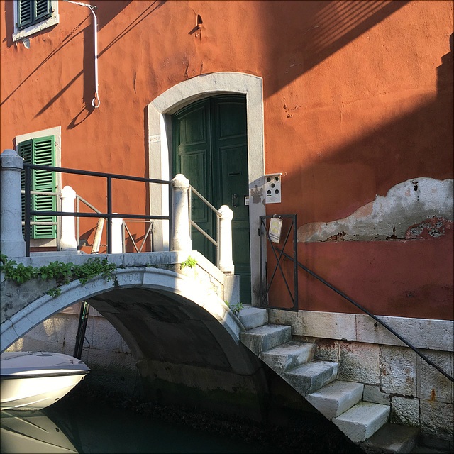 A bridge in front of the door, a stair into the water.