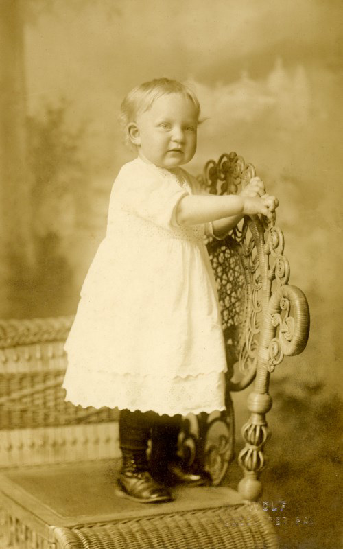 Erma Herr Standing on a Wicker Chair