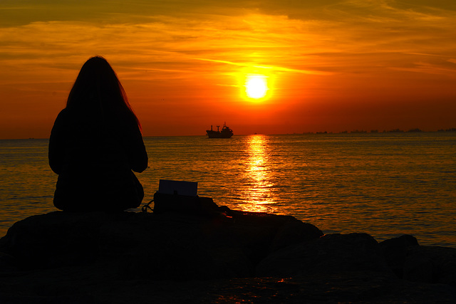 Lady sitting on the sea wall