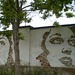 Carved murals by Vhils, on inside wall of ancient factory.